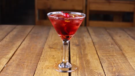 Waiter-dropping-a-cherry-into-a-red-fruit-cocktail