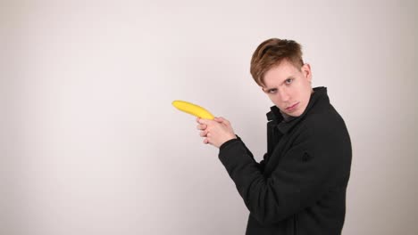 Male-detective-walking-backwards-with-a-banana-pistol