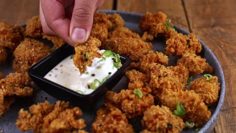 closeup-of-hand-dipping-a-piece-of-chicken-into-a-ranch-dip
