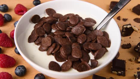 Pouring-chocolate-cereal-on-a-bowl-of-yogurt