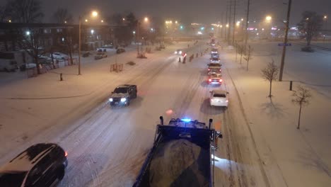 Aerial-footage-captures-the-snow-plow-as-it-efficiently-clears-snow-in-a-traffic-jam-during-a-red-light,-making-transportation-in-winter-more-efficient-and-safer