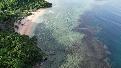 Amazing-Aerial-view-of-Coastal-Reef-under-transparent-Sea-Waves-next-to-white-sand-beach-in-Catanduanes,-Philippines
