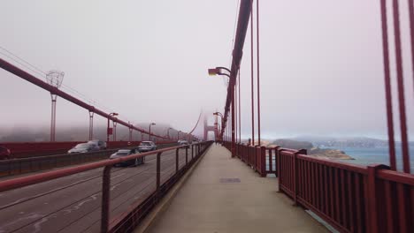 Cardán-Pov-Tiro-De-Una-Bicicleta-En-Movimiento-Cruzando-El-Puente-Golden-Gate-En-Un-Día-De-Niebla-En-San-Francisco,-California