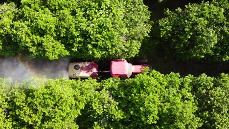 Close-up-drone-shot-following-tractor-spraying-chemicals-on-farmland