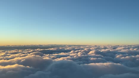 Atemberaubende-Aussicht,-Aufgenommen-Aus-Einem-Jet-Cockpit,-Während-Man-Bei-Sonnenuntergang-Knapp-über-Den-Wolken-Fliegt