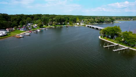 Aerial-view-of-peaceful-small-residential-harbor-place-with-boats-docked-on-the-banks,-captured-during-sunshine-day,-location-West-Michigan,-USA