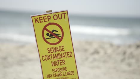 Halten-Sie-Abwasser-Und-Verunreinigtes-Wasser-Fern.-Vorsichtsschild-Am-Imperial-Beach-In-Kalifornien,-Sonniger-Tag-–-Nahaufnahme-In-Zeitlupe