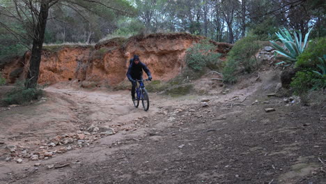 mountain-biker-navigates-a-sharp-bend-on-a-rugged-dirt-track-that-winds-through-a-dense-forest