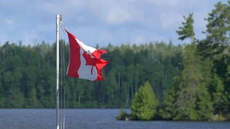 4K-Zeitlupenaufnahme-Mit-Kanadischer-Flagge,-Die-In-Der-Brise-Der-Quetico-Wildnis-Flattert