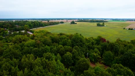 Majestic-aerial-video-shoot-of-vast-agriculture-fields-and-forest,-location-West-Michigan,-USA