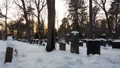 Bunch-of-snow-covered-graves-in-a-graveyard-during-the-sunset