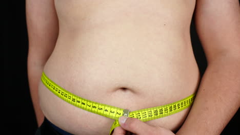 Übergewichtiger-Teenager-Misst-Seinen-Bauch-Mit-Messgerät,-Nahaufnahme