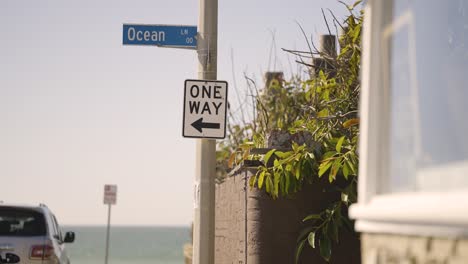 Blaues-Ocean-Lane-Straßenschild-Mit-Einbahnstraßenschild-Und-Pazifischem-Ozean-Im-Hintergrund