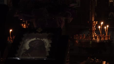 Brennende-Kerzen-Flackern-Neben-Einem-Orthodoxen-Christlichen-Gemälde,-Das-Jesus-Christus-Darstellt