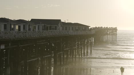 Pacific-Beach-California-Pier-Sunset-with-Waves-Crashing-on-Beach---Slow-Motion-from-right-side-of-Pier