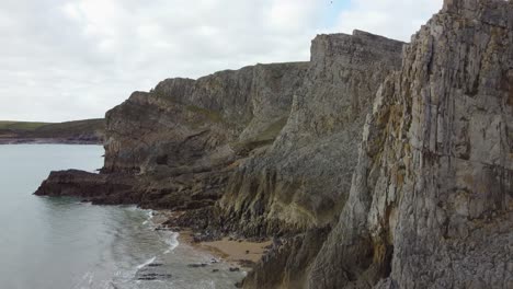 Layered-Sea-Cliffs-as-Aerial-Shot-Rises-to-Reveal-Small-Enclosed-Bays-and-Coastal-Erosion-4K-Wales-UK
