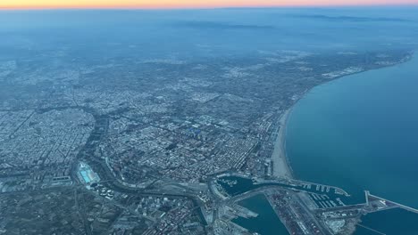 Aerial-view-of-Valencia-city,-in-SE-Spain-at-sunset,-from-a-jet-cockpit