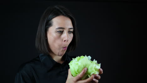 Young-Woman-Biting-Cabbage,-Vegan-Diet-and-Healthy-Food-Concept,-Black-Background