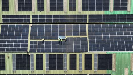 Factory-workers-installing-photovoltaic-panels-on-roof