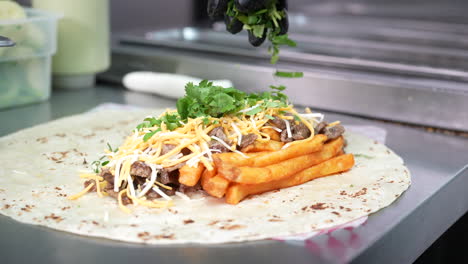 Making-a-California-Burrito-with-fries,-meat,-cheese,-cilantro---food-truck-series
