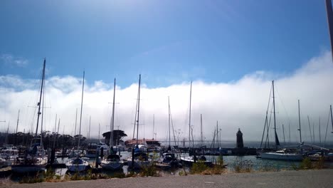 Time-lapse-of-clouds-and-fog-rolling-in-over-the-Golden-Gate-Bridge-and-boat-marina-in-San-Francisco,-California