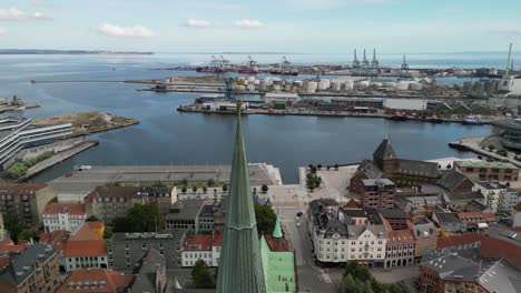 Aarhus-Cathedral-Spire-Orbit-with-City-Aerial,-Aarhus,-Denmark