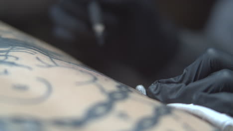 Tatuador-Profesional-Usando-Palo-Y-Mano-Y-Tinta-Negra