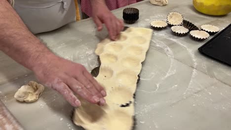 Baber-Tradicional-Prepara-Pastelitos-Caseros-En-Su-Panadería,-Sobre-Una-Mesa-De-Mármol