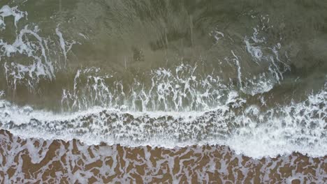 Top-Down-Aerial-Drone-of-Gentle-Sea-Waves-Rolling-in-UK-4K