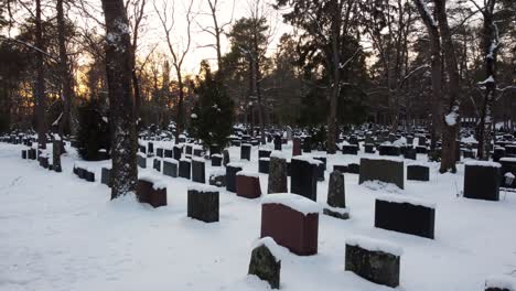 Bunch-of-snow-covered-graves-in-a-graveyard-during-the-sunset