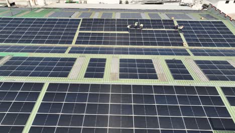 Workers-on-factory-roof-installing-solar-panels