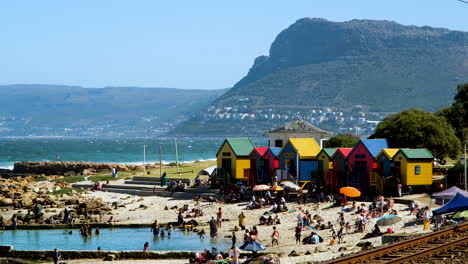 Colorful-Victorian-style-bathing-boxes-on-tidal-pool,-St-James-beach,-Muizenberg