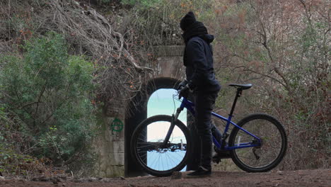 cyclist-stops-to-look-through-tunnel-leading-to-sea-and-rides-on