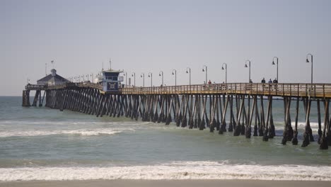 Imperial-Beach-Pier-in-Southern-California-with-waves-during-a-sunny-day---slow-motion