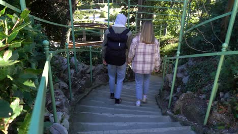 Young-couple-walking-down-the-stairs-in-the-park