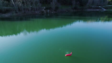 Oxygen-rises-to-the-surface-in-a-green-lake,-around-a-red-buoy