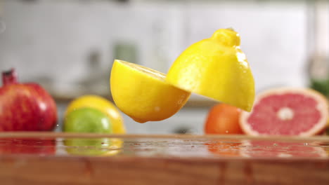 Slow-motion-of-sliced-in-half-lemon-falling-on-wet-wooden-board-in-a-kitchen