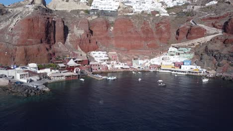 Aerial-Drone-Video-Of-Beautiful-Bay-Of-Ammoudi-Below-Picturesque-Village-of-Oia,-Santorini