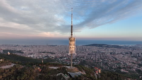 Collserola-antenna-tower-at-sunset-on-Tibidabo-with-Barcelona-city-in-background,-Spain