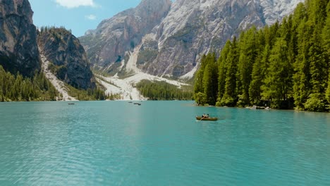Aerial-shot-of-a-drone-going-fast-through-the-river-with-the-Dolomites-Alps-in-the-back,-Lago-di-Braies,-Italy,-Dolomites