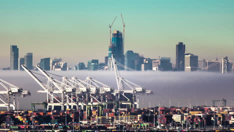 Time-lapse-shot-of-low-Clouds-flying-over-container-port-of-San-Francisco-with-skyline-in-background-at-sunrise
