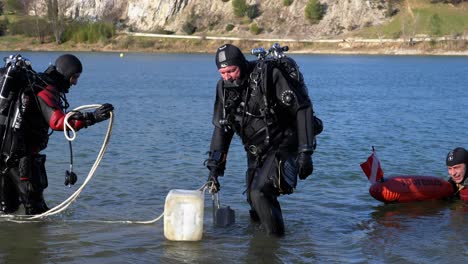 3-divers,-equipped-with-their-oxygen-cylinder,-come-out-of-the-water-in-south-of-France