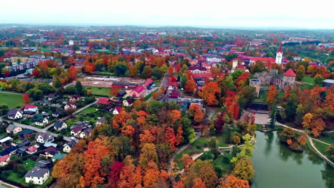 Drone-trucking-tilt-shot-of-Cesis-castle-in-Latvia-surrounded-by-autumn-colored-trees