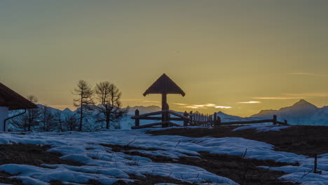 Wunderschöner-Sonnenaufgang-Auf-Dem-Gipfel-Des-Schneebedeckten-Berges-Und-Gipfelkreuzes-Während-Eines-Wintertages,-Zeitraffer