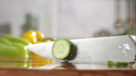 Slow-motion-of-cucumber-sliced-with-a-knife-on-wooden-board-in-a-kitchen