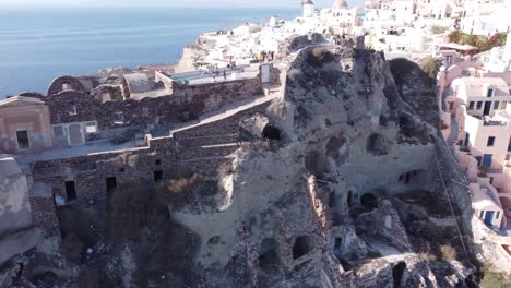 Cinematic-aerial-shot-of-famous-Oia-castle-in-Santorini-at-sunrise-in-Greece