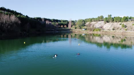Two-divers-swim-towards-the-third-diver-in-a-lake-in-the-south-of-France-in-the-middle-of-winter
