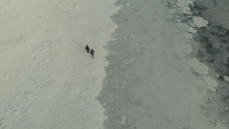 Drone-shot-of-people-walking-in-the-snow
