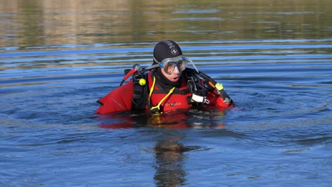 A-diver-enters-water-at-4-degrees,-he-is-equipped-with-a-red-suit