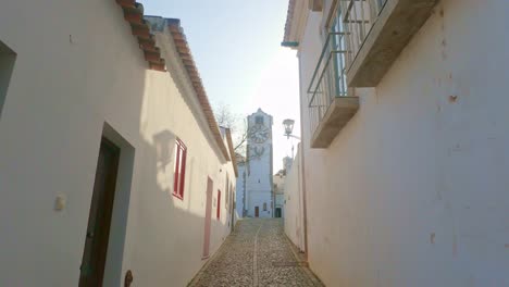 Narrow-laneway-to-Santa-Maria-Church-Tavira-Algarve,-old-historic-streets-and-laneways-at-sundown-on-a-warm-spring-evening